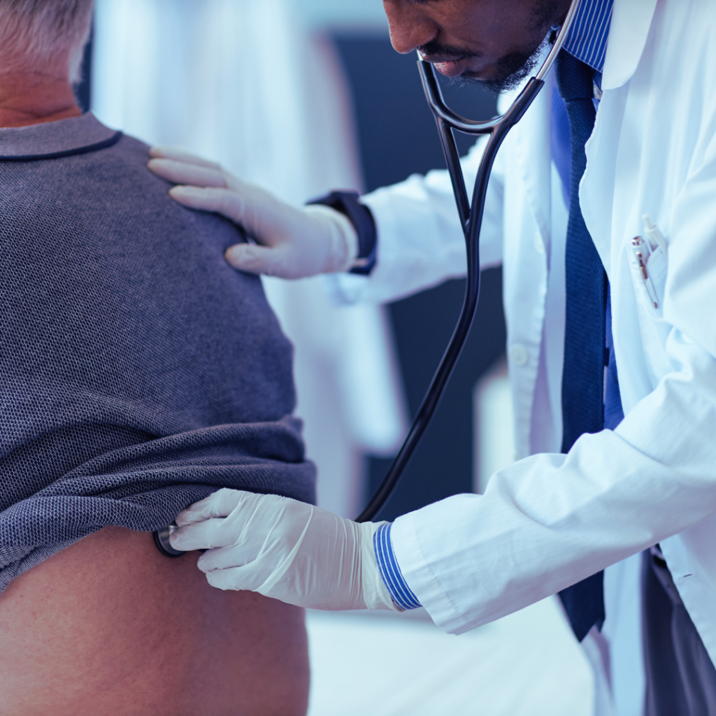 a doctor holding a stethoscope to a patients back