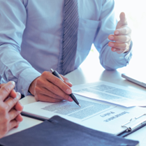 Person explaining insurance papers to someone else at the table, off screen